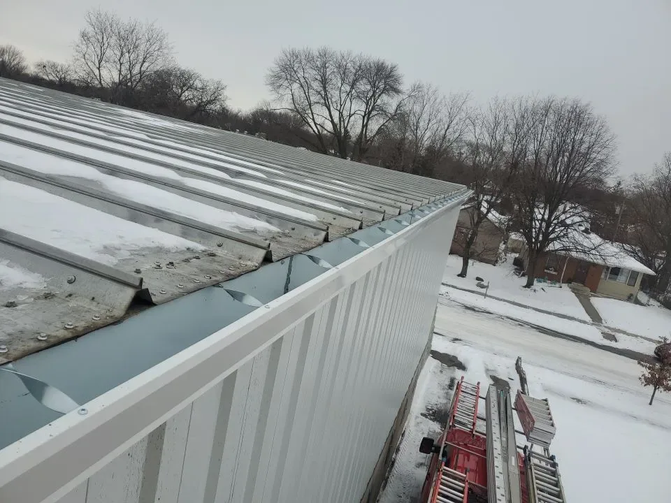 Edge metal and coping on a snowy commercial roof